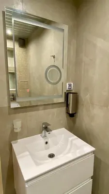 a bathroom with a white sink and a mirror at Paradise Swing Apartment Sofia in Sofia