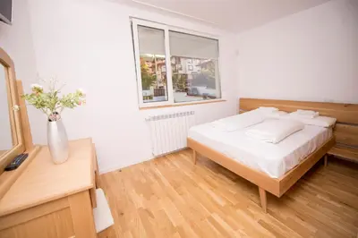 a bedroom with a bed and a vase of flowers at Villa Detelina in Sapareva Banya