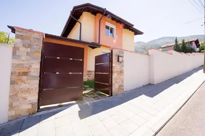a house with two garage doors on a driveway at Villa Detelina in Sapareva Banya