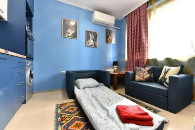 a living room with a couch and a blue wall at Bansko Studio 30m From Gondola - T.K. 4B in Bansko