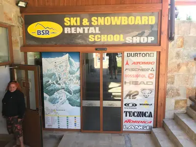 a woman standing in the doorway of a ski and snowboard rental school at Bansko Studio 30m From Gondola - T.K. 4B in Bansko