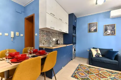a kitchen and dining room with blue walls and a table and chairs at Bansko Studio 30m From Gondola - T.K. 4B in Bansko