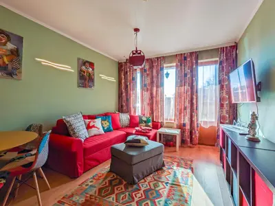 a living room with a red couch and a tv at Gondola 1 BDRM Flat in Cedar Lodge IV (D2) in Bansko