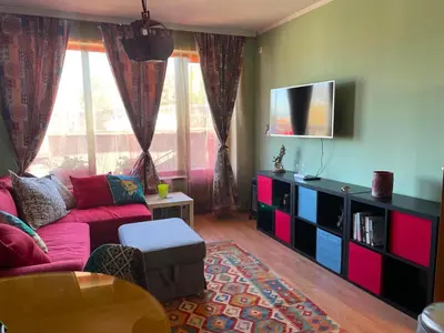 a living room with a red couch and a tv at Gondola 1 BDRM Flat in Cedar Lodge IV (D2) in Bansko