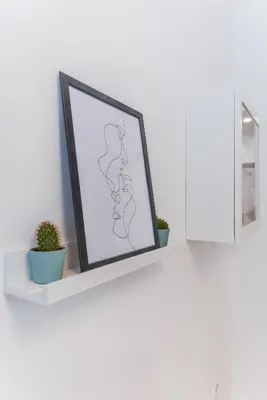 a picture frame sitting on a shelf with two plants at Cosy & renovated 2BD flat near Vitoshka by Flat Mаnager in Sofia