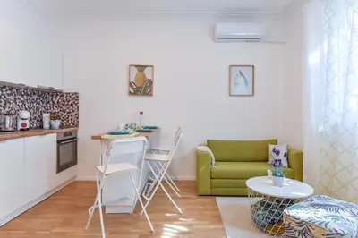 a living room with a table and a green couch at Cosy & renovated 2BD flat near Vitoshka by Flat Mаnager in Sofia