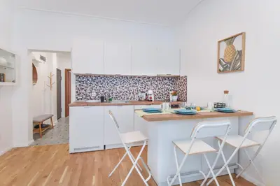 a kitchen with white cabinets and white stools at Cosy & renovated 2BD flat near Vitoshka by Flat Mаnager in Sofia