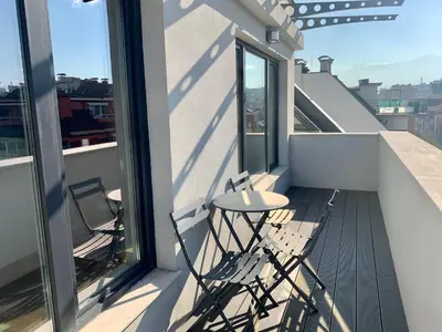 a balcony with two chairs and a table on a building at Gardenia Apartments in Sofia