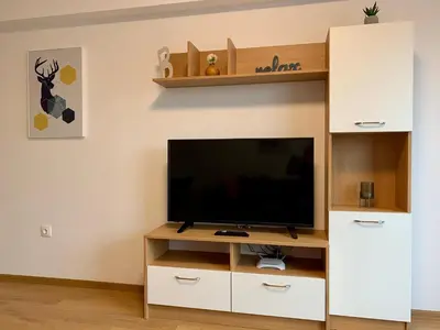 a living room with a television on a white entertainment center at Gardenia Apartments in Sofia