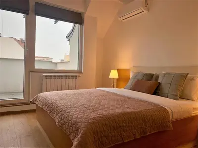 a bedroom with a bed and a large window at Gardenia Apartments in Sofia
