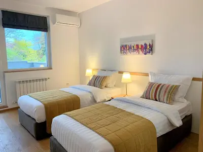 a hotel room with two beds and a window at Gardenia Apartments in Sofia