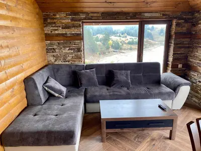 a living room with a couch and a table at Къщи за гости 