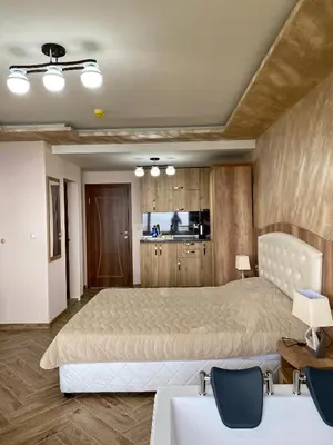 a large bedroom with a large bed and wooden cabinets at Къщи за гости 