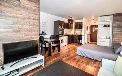 a living room with a bed and a kitchen at Bansko Royal Towers Apartments - Gondola View in Bansko