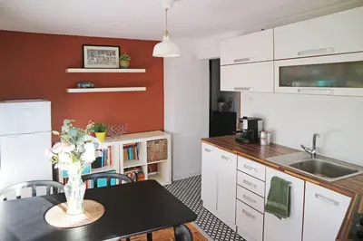 a kitchen with a table with a vase of flowers on it at Modern Cozy Apartment in Kyustendil