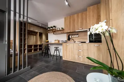 a kitchen with wooden cabinets and a table with a vase of flowers at Borovete Mountain Luxury in Borovets