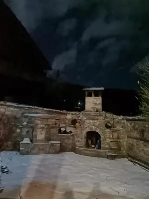 a stone fireplace at night with a dark sky at Къща за гости Кануш войвода in Kovachevitsa