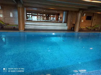 a large blue swimming pool in a building at Mountain view Private apartments in Pirin Golf and SPA resort in Razlog