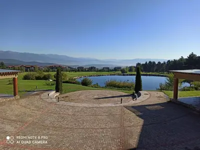 a park with a lake in the background at Mountain view Private apartments in Pirin Golf and SPA resort in Razlog