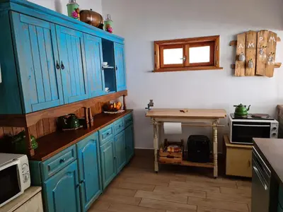 a kitchen with blue cabinets and a table in it at къща Слави in Oreshak
