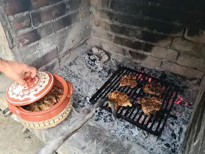 a person is cooking food on a grill at къща Слави in Oreshak
