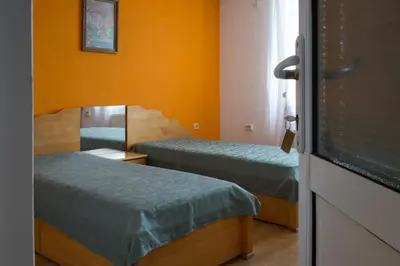 a small room with two beds and a mirror at къща Слави in Oreshak