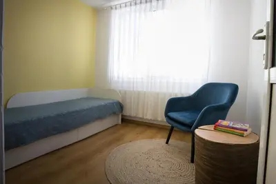 a bedroom with a bed and a chair and a table at къща Слави in Oreshak