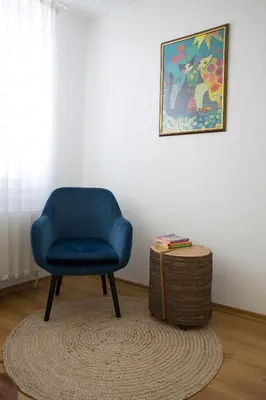 a blue chair and a table in a room at къща Слави in Oreshak