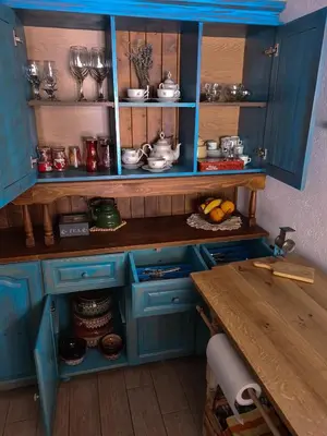 a blue kitchen with blue cabinets and a table at къща Слави in Oreshak