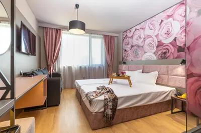 a bedroom with a bed with a pink floral wall at Hotel Urban in Plovdiv