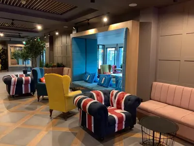 a lobby with couches and chairs and a mirror at Hotel Urban in Plovdiv