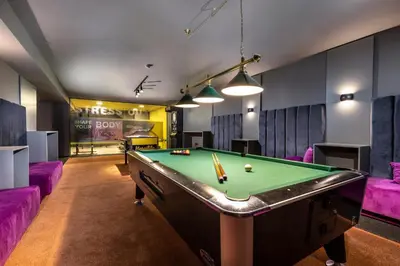 a billiard room with a pool table and purple couches at Hotel Urban in Plovdiv