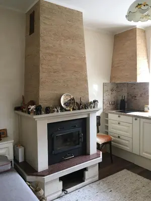 a living room with a fireplace and a kitchen at Willy Villy`s house in Chepelare