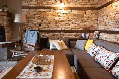 a living room with a couch and a wooden table at LITTLE BIRD Residency - Luxury Guesthouses in Leshten in Leshten