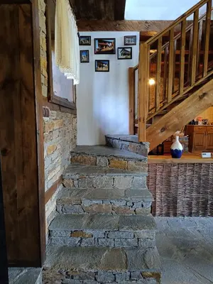 a stone staircase in a house with a wooden stair case at LITTLE BIRD Residency - Luxury Guesthouses in Leshten in Leshten