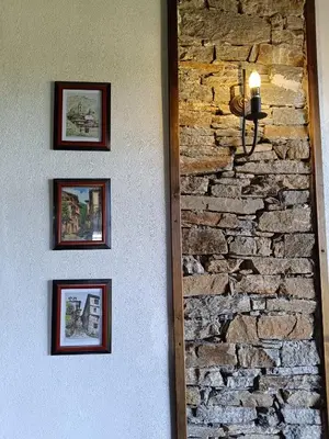 a wall with three pictures on a stone wall at LITTLE BIRD Residency - Luxury Guesthouses in Leshten in Leshten