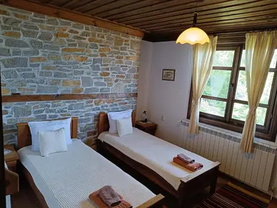 two beds in a room with a brick wall at LITTLE BIRD Residency - Luxury Guesthouses in Leshten in Leshten