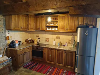 a kitchen with wooden cabinets and a stainless steel refrigerator at LITTLE BIRD Residency - Luxury Guesthouses in Leshten in Leshten
