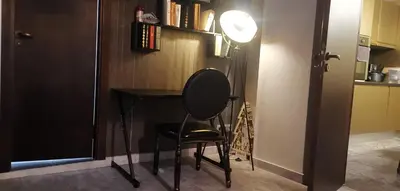a room with a desk and a chair and a lamp at Мирков Дар in Bansko