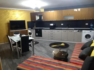 a living room with a couch and a table and a kitchen at Valentina GOLD apartment in Plovdiv