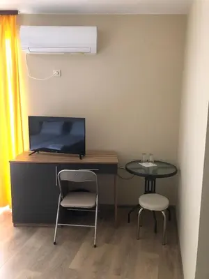 a desk with a computer and a table and two chairs at Стаи за гости Праматарови Огняново in Ognyanovo