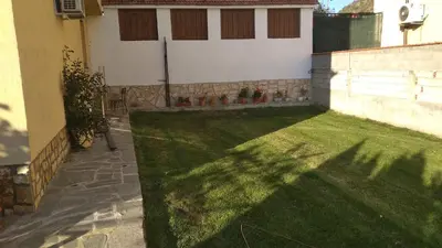 a backyard with a green lawn and a building at Стаи за гости Праматарови Огняново in Ognyanovo