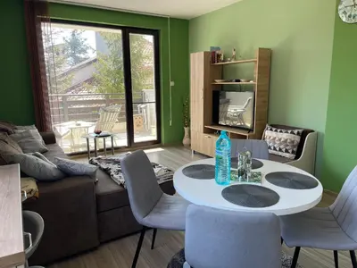 a living room with a table and chairs and a couch at Nikol Deluxe in Velingrad