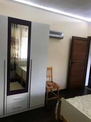 a bedroom with a mirror and a chair and a window at Sharkov Guest House in Dolen