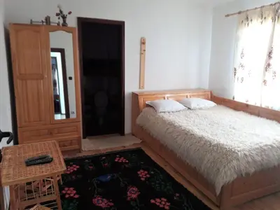 a bedroom with a bed and a window and a table at Sharkov Guest House in Dolen