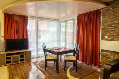 a dining room with a table and chairs and a television at 2 bedroom, 2 showeroom Villa suitable for a family skication and remote working in Pamporovo