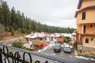 a group of buildings with cars parked in a parking lot at 2 bedroom, 2 showeroom Villa suitable for a family skication and remote working in Pamporovo