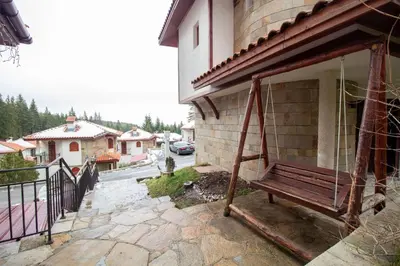 a wooden bench sitting on the side of a building at 2 bedroom, 2 showeroom Villa suitable for a family skication and remote working in Pamporovo