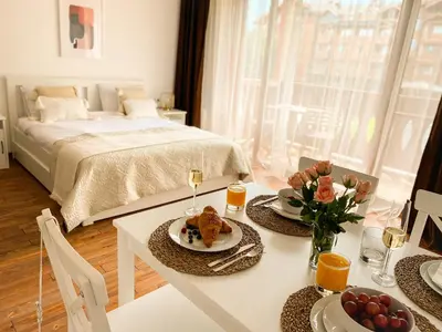 a room with a bed and a table with food on it at Pirin Golf Studio Apartment in Razlog