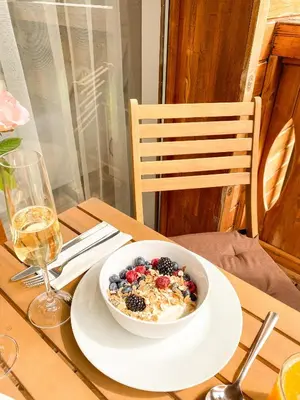 a bowl of cereal and berries on a plate on a table at Pirin Golf Studio Apartment in Razlog